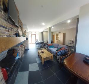 a living room with a couch and a table at La Forge De Labbaye in Liessies