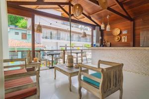 a restaurant with tables and chairs and a bar at Pousada Mareia in Morro de São Paulo