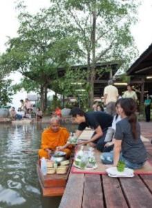a group of people sitting on a boat in the water at อัมพวาริเวอร์วิว Amphawa River View in Samut Songkhram