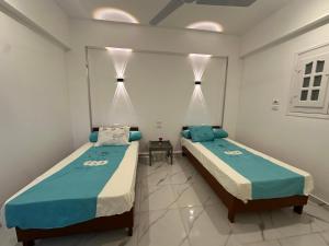 two beds in a room with at golden house in Al Aqālitah