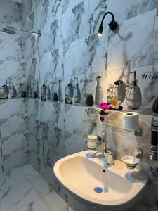 a bathroom with a sink and a marble wall at golden house in Al Aqālitah