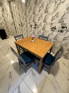 a wooden table and chairs with a vase on it at golden house in Al Aqālitah