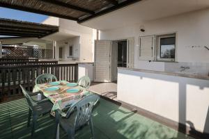 a patio with a table and chairs on a deck at Ocra Fronte Mare in Torre Mozza