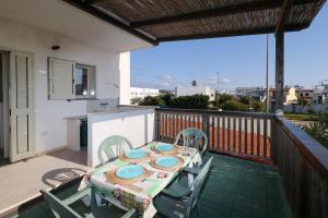 a table and chairs on a balcony with a view of the city at Ocra Fronte Mare in Torre Mozza