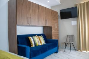 a blue couch in a bedroom with a tv at Augustea Travel Rooms in Frignano