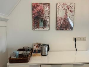 a kitchen counter with two pictures on the wall at B&B De Holevoet in Scherpenzeel