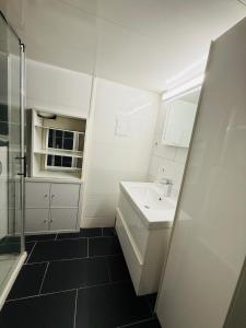 a white bathroom with a sink and a shower at Schones Apartment mit Charme und privatem Garten in Schwieberdingen