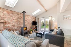 a living room with a brick wall and a fireplace at 3 Bed in Hindolveston oc-1986 in Hindolveston