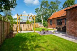 a garden with a yellow pergola in a yard at 3 Bed in Hindolveston oc-1986 in Hindolveston