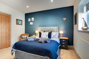 a bedroom with a blue wall and a bed with pillows at 3 Bed in Hindolveston oc-1986 in Hindolveston