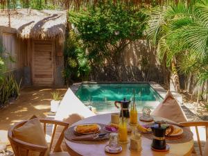 a table with food on it next to a swimming pool at Private Pool Romantic Villa - Adults Only - VILLA PALMA - Gili Meno in Gili Meno