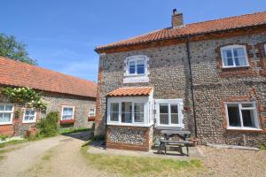 an old brick house with a picnic table in front of it at 2 Bed in Blakeney oc-1805 in Blakeney