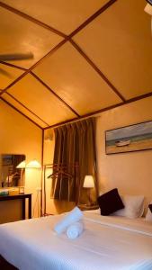 a bedroom with a large bed with a ceiling at Coco Seaweed Resort in Semporna