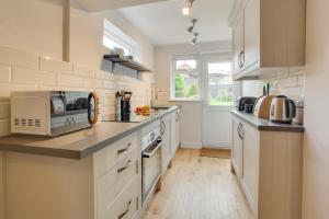 a kitchen with white cabinets and a counter top at 2 Bed in Dersingham oc-2154 in Dersingham +5 photos