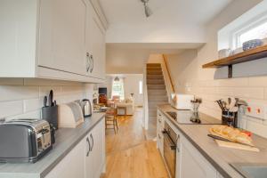 a kitchen with white cabinets and a living room at 2 Bed in Dersingham oc-2154 in Dersingham