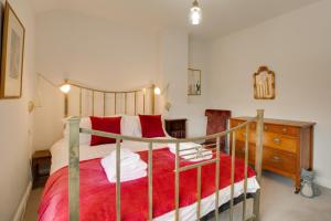 a bedroom with a large bed with red pillows at 2 Bed in Dersingham oc-2154 in Dersingham