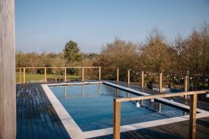 a swimming pool on top of a wooden deck at Chez Lilie in Le Sel