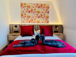 two people laying on top of a bed with towels at Villa Peonia-Szauna & Relax in Keszthely