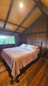 a bedroom with a bed in a wooden room at Chalé lindo e confortável! in Massaranduba