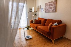 a living room with a brown couch and a table at Mami's in Alexandroupoli