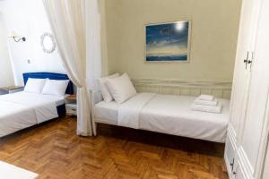 two beds in a room with wooden floors at Mami's in Alexandroupoli
