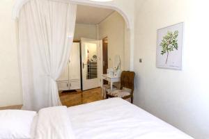 a bedroom with a white bed and a mirror at Mami's in Alexandroupoli +2 photos