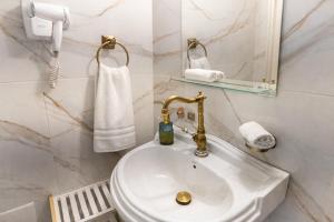 a white bathroom with a sink and a mirror at Mami's in Alexandroupoli