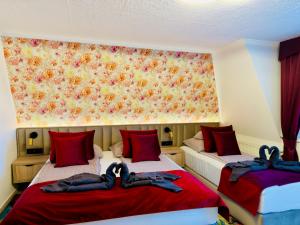 two beds in a room with red pillows at Villa Peonia-Szauna & Relax in Keszthely