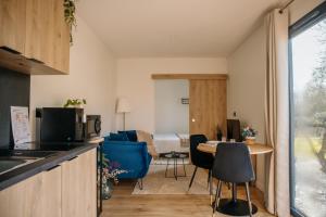 a kitchen and living room with a table and chairs at Chez Lilie in Le Sel