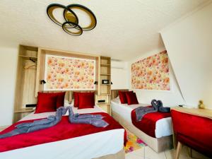 two beds in a room with red pillows at Villa Peonia-Szauna & Relax in Keszthely
