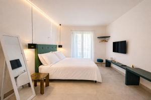 a bedroom with a white bed and a television at TerrAmare Suites in Baronissi