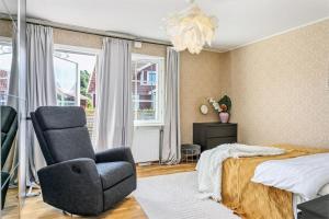 a bedroom with a chair and a bed and a chandelier at Luxury villa with pool in Bro +27 photos