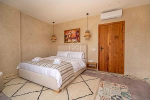 a bedroom with a bed and a wooden door at Chambre avec vue panoramique in Noûnouech +11 photos