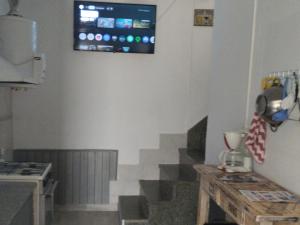 a television on the wall of a kitchen with stairs at Vm casa in Villa María