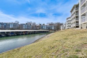 a river with apartment buildings and a bridge at Lake View + Pool Access: Waterfront Ozark Escape! in Four Seasons