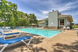 a swimming pool with lounge chairs and a house at Lake View + Pool Access: Waterfront Ozark Escape! in Four Seasons