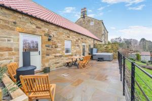 a stone house with a patio with a table and chairs at 2 Bed in Castleton oc-f34013 in Castleton