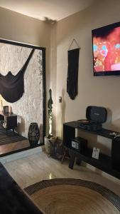 a living room with a large mirror and a tv at Bokoba Condo Tulum Maia in Tulum