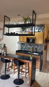 a kitchen with a table and a counter with chairs at Bokoba Condo Tulum Maia in Tulum