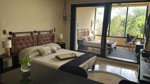 a bedroom with a bed and a table and a balcony at Bokoba Condo Tulum Maia in Tulum +14 photos