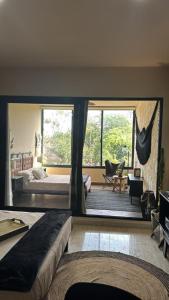 a bedroom with two beds and a large window at Bokoba Condo Tulum Maia in Tulum