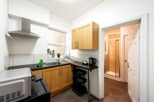 a small kitchen with a sink and a microwave at Spacious City-Centre Apartment · Sleeps 4 in Nottingham