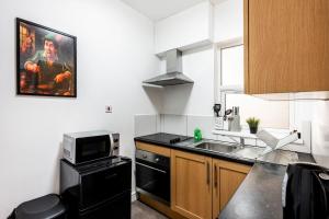 a small kitchen with a sink and a microwave at Spacious City-Centre Apartment · Sleeps 4 in Nottingham +23 photos