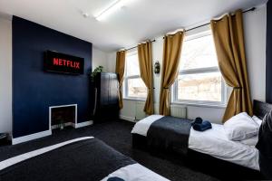 a bedroom with two beds and a sign on the wall at Spacious City-Centre Apartment · Sleeps 4 in Nottingham