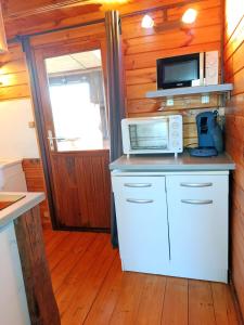 a kitchen with a counter top with a microwave at Chalet à la campagne in Clais +18 photos