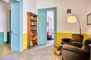 a living room with two chairs and a book shelf at Palazzo Mercanzia in Lecce