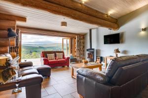 a living room with leather furniture and a large window at 4 Bed in Alston oc-nb575 in Alston
