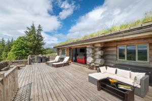 a wooden deck with couches and chairs on a cabin at 4 Bed in Alston oc-nb575 in Alston