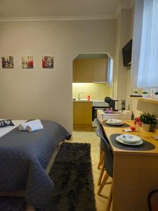 a bedroom with a bed and a table and a kitchen at B&M Cozy Corner in Igoumenitsa