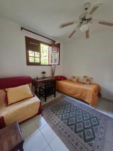 a bedroom with two beds and a couch and a window at Chrysalide in Baillif